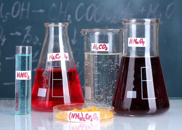 Testtubes with various acids and other chemicals on the background of the blackboard