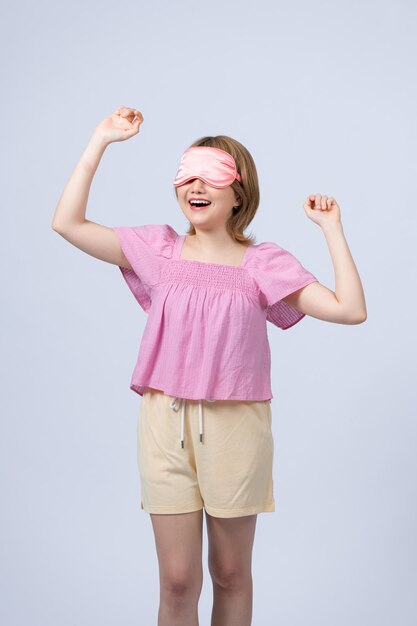 Tevreden Aziatische vrouw houdt ogen gesloten glimlach verbeeldt zich zachtjes iets aangenaams draagt een slaapmasker geïsoleerd op witte achtergrond