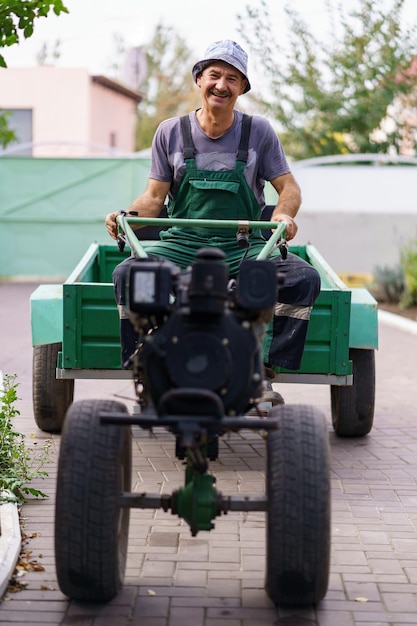 Tevreden boerenportret zittend achter het stuur van een tweewielige tractor