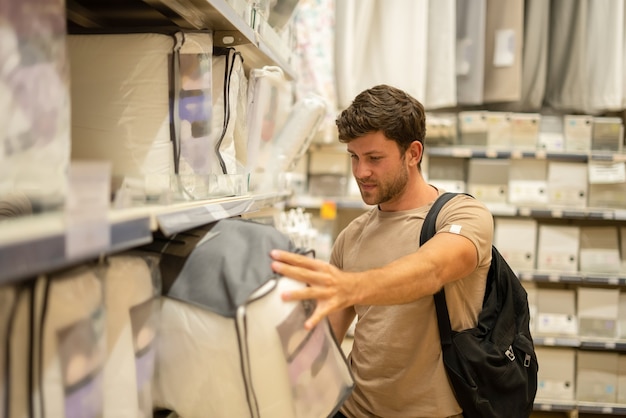 Tevreden man die kussens plukt in linnenwinkel