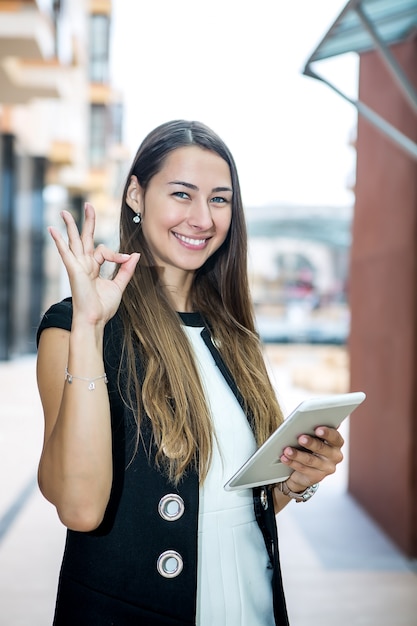 Tevreden onderneemster het gesturing met tablet