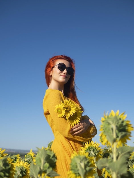 Tevreden vrouw met zonnebloemen in veld