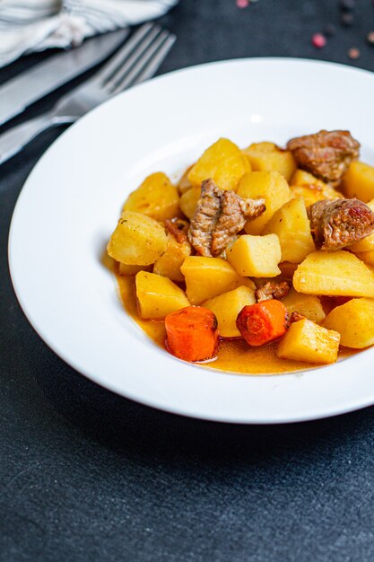 Foto porzione di gulasch con patate e verdure arrosto di carne