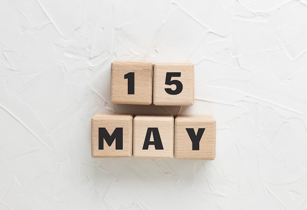 Text 15 may made of wood cubes on white textured putty
background. armed forces day 2021. honoring and mourning military.
square wood blocks. top view, flat lay.