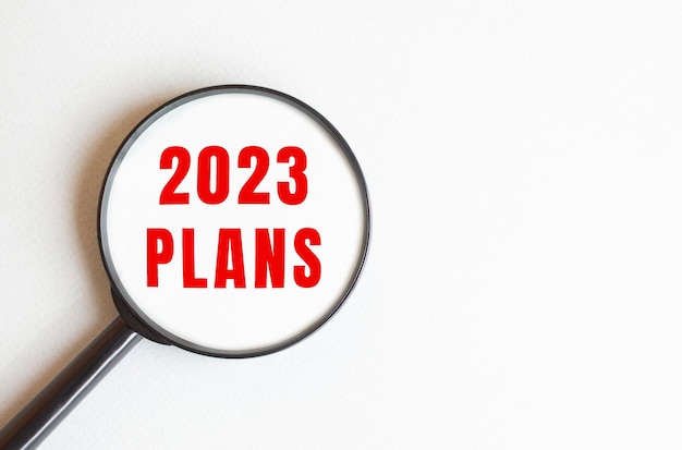 The text 2023 PLANS is written on a gray background We read through a magnifying glass