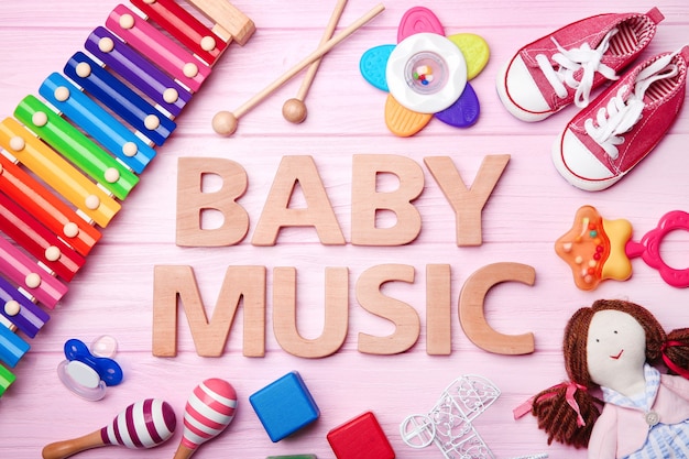 나무 테이블에 텍스트 BABY MUSIC 및 장난감