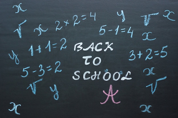 Text Back to school and mathematical examples on black chalkboard