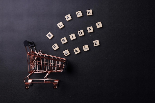 text Black Friday Sale and shopping cart on a black background