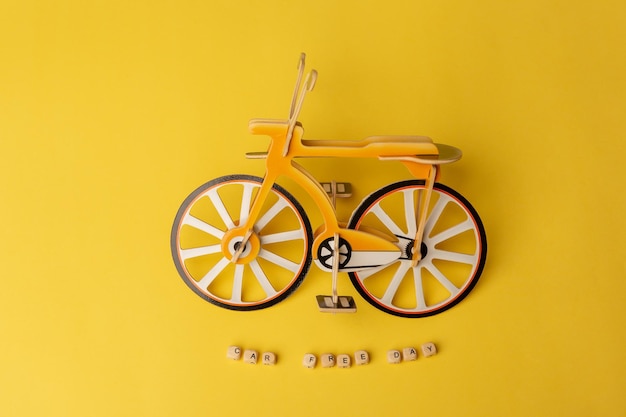 Text car free day and small toy bicycle on yellow background\
concept of world car free day