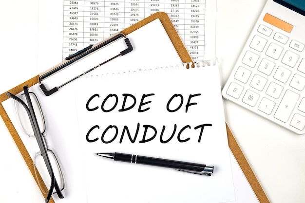 Photo text code of conduct on the white paper on clipboard with chart and calculator