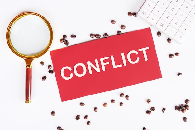 The text of the conflict is on a red card coffee beans and a magnifying glass on a white background are scattered nearby