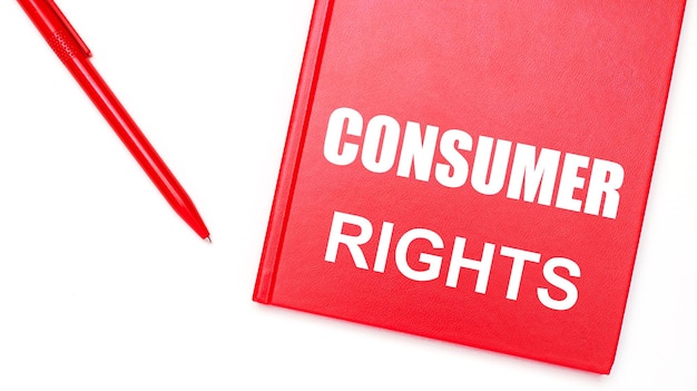 CONSUMER RIGHTS라는 텍스트는 사무실 비즈니스 개념의 흰색 테이블에 있는 빨간색 펜 근처의 빨간색 메모장에 쓰여 있습니다.