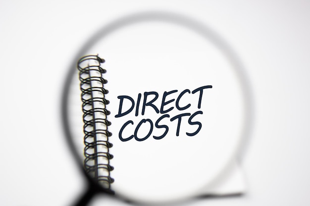 虫眼鏡を通してメモ帳に「DIRECT COSTS」と入力してください