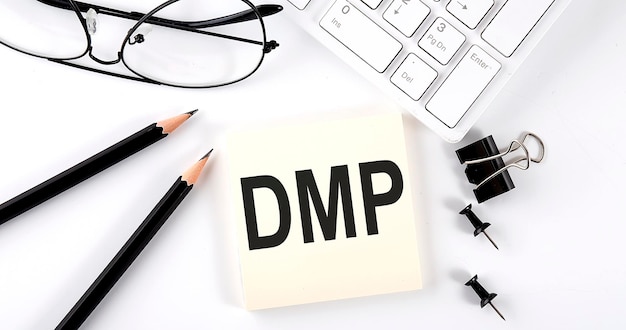 Text DMP on the sticker with keyboard pencils and office tools