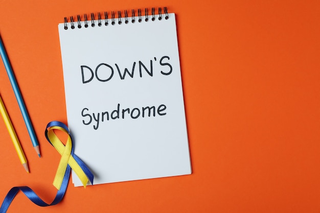 Photo text down's syndrome, awareness ribbons and pencils on orange