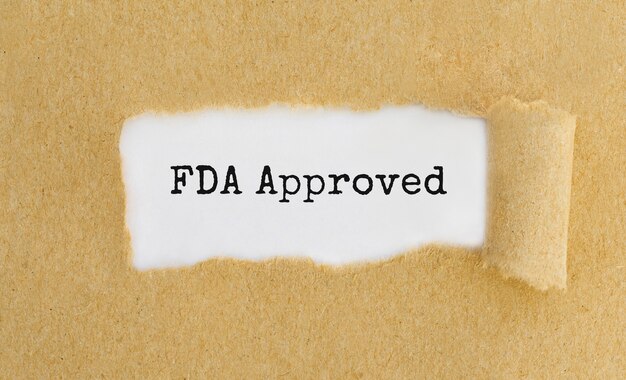 찢어진 갈색 종이 뒤에 텍스트 FDA 승인 표시.