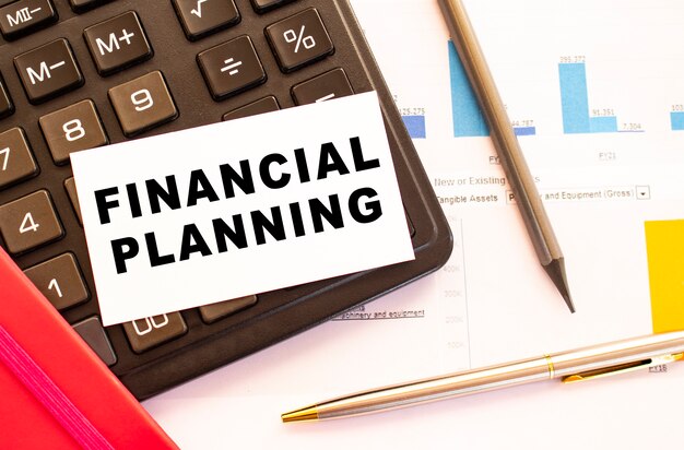 Photo text financial planning on white card with metal pen, calculator. business and financial concept