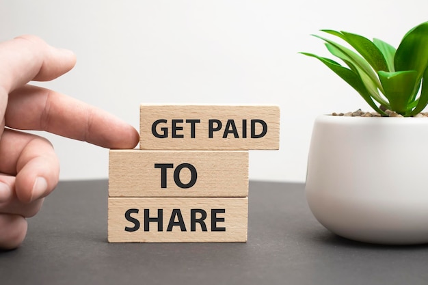 Текст Get Paid To Share на деревянных блоках