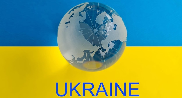 Text help to Ukraine with transparent globe on background of Ukrainian flag