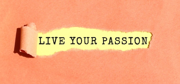 The text live your passion appearing on yellow paper behind torn color paper top view