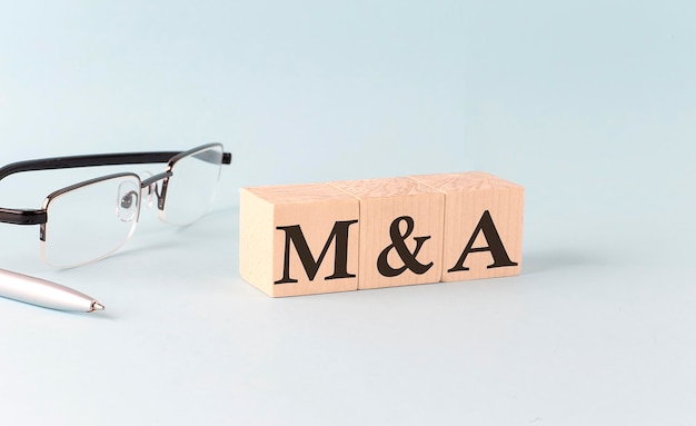 Text M and A written on the wooden cubes on blue background