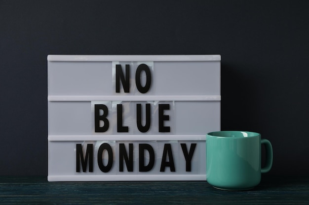 Photo text no blue monday and cup on dark blue background