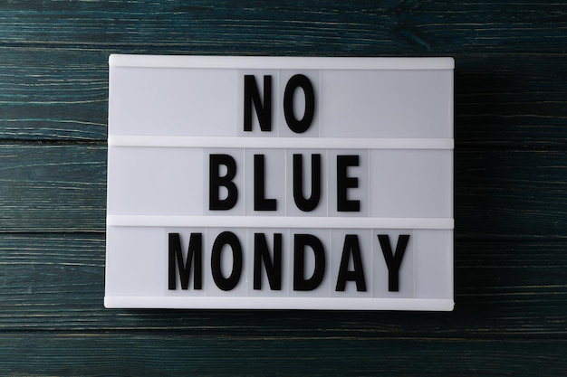 Text No Blue Monday on dark blue wooden background top view