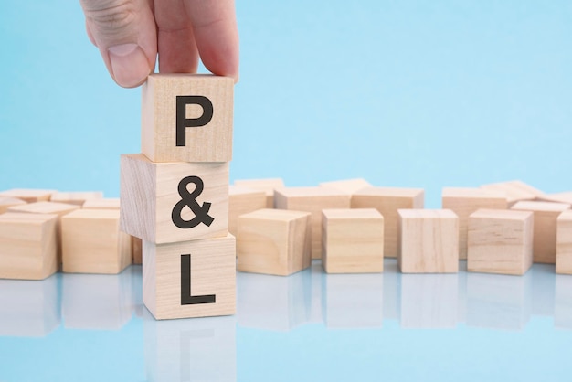 Text P and L written on wooden cubes on blue background