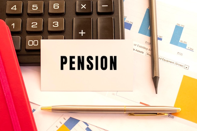 흰색 카드에 텍스트 PENSION입니다. 금속 펜, 계산기 및 재무 차트. 금융 개념입니다.