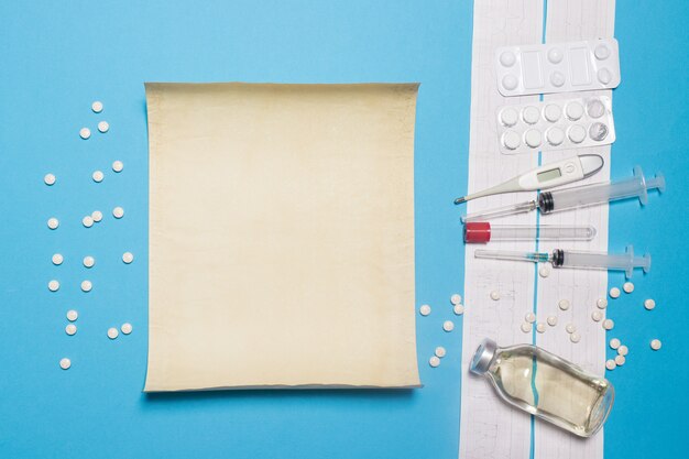 Photo text sheet and ecg tape with medicines on a blue background