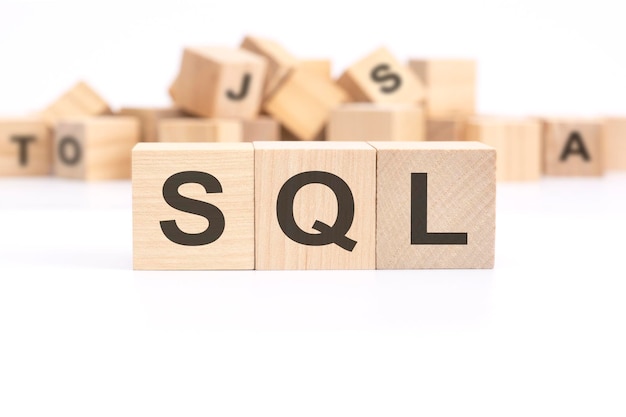 テキスト SQL セールス認定リードは、背景の白いテーブルの上に立つ 3 つの木製キューブに書かれており、文字が付いた木製キューブの山です。