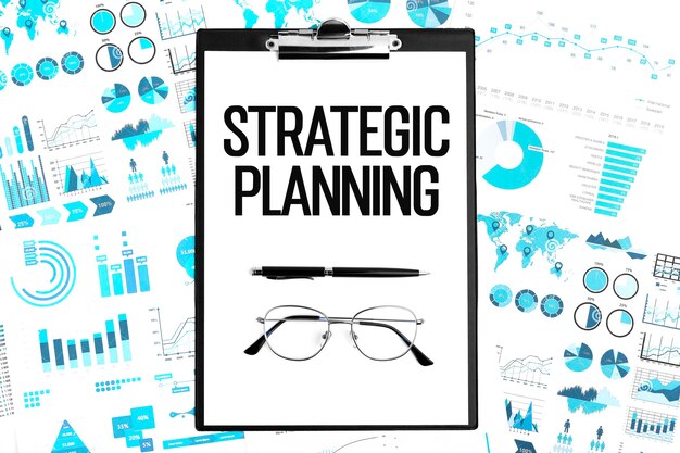 Photo text strategic planning on clipboard, glasses and graphs. business concept. flat lay.