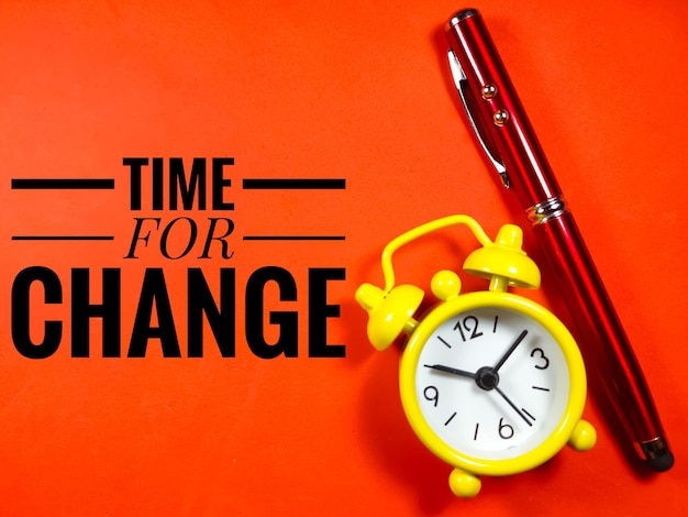 Text TIME FOR CHANGE with pen and clock on red background