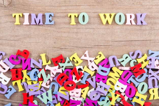 Text Time to work of colored wooden letters on a wooden background