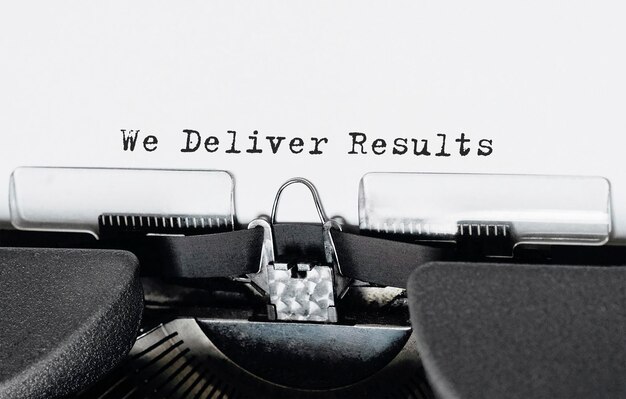 レトロなタイプライターで入力された「We Deliver Results」というテキスト