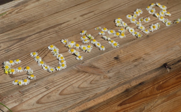 text with flowers on vintage wooden background