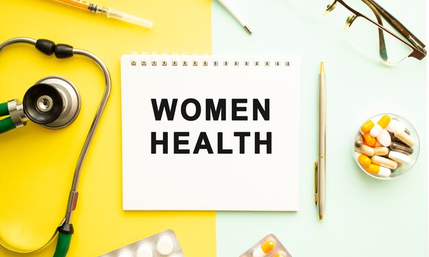 Text WOMEN HEALTH on notebook with stethoscope and pen