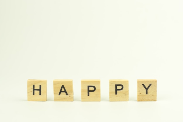 Text wooden blocks spelling the word HAPPY on white background