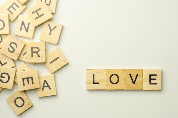 Text wooden blocks spelling the word love on white background