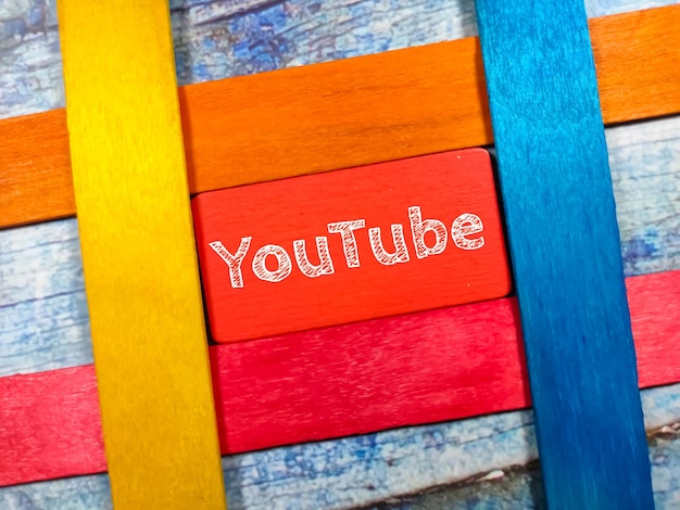 Text YouTube writing on colored board with colorful ice cream sticks on a wooden background