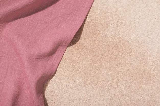 Textiel roze servet op beige gepleisterde achtergrond