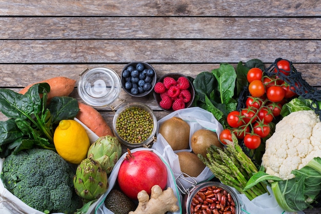 農産物、果物、野菜が入ったテキスタイルメッシュバッグ。ゼロウェイスト、環境にやさしい、プラスチックフリーのリサイクル、再利用可能、持続可能な食料品の買い物のコンセプト。コピースペース、フラットレイの背景