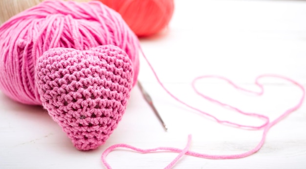 Textile pink heart with skeins of yarn