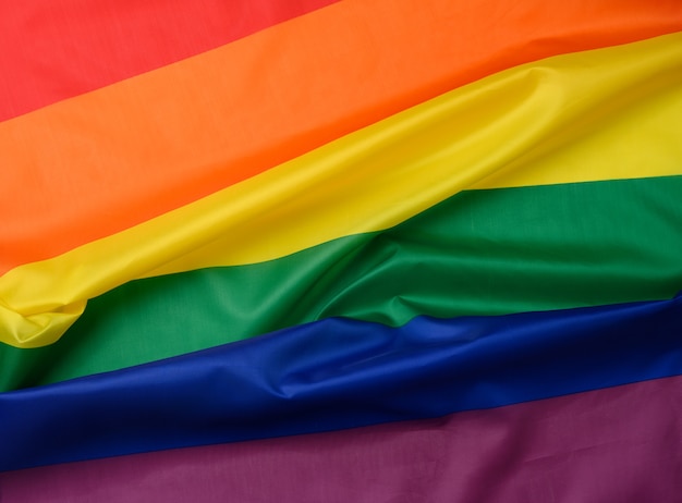 Textile rainbow flag with waves, symbol of freedom of choice of lesbians, gays, bisexuals and transgender people, LGBT culture, close up