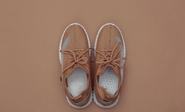 Textile sports shoes on brown background. top view