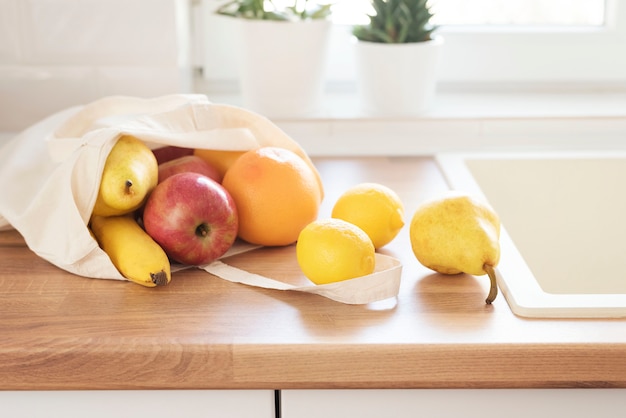 Foto borsa di stoffa riempita di frutta fresca sul bancone della cucina