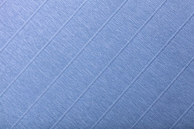 Textural of navy blue background of wavy corrugated paper, closeup.