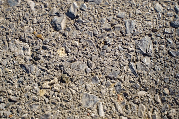 The texture of the asphalt pavement interspersed with stones
