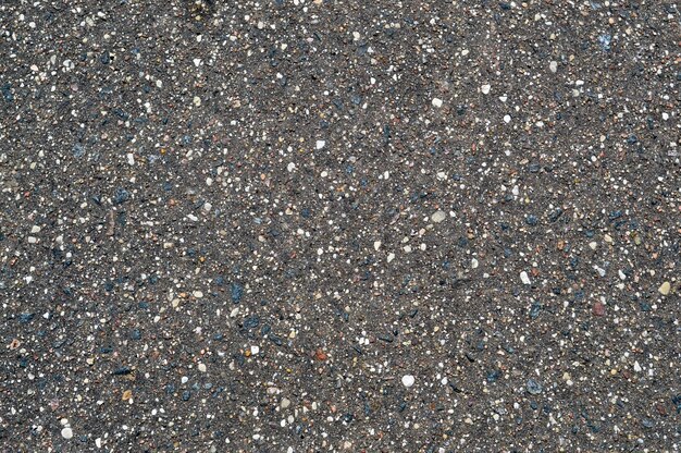 the texture of the background of stone black gray asphalt road with small pebbles