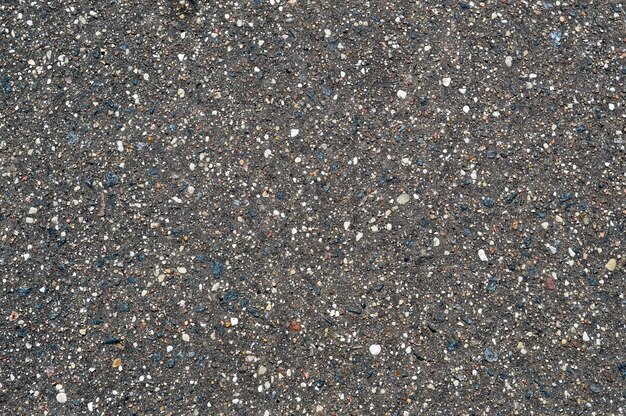 The texture of the background of stone black gray asphalt road with small pebbles